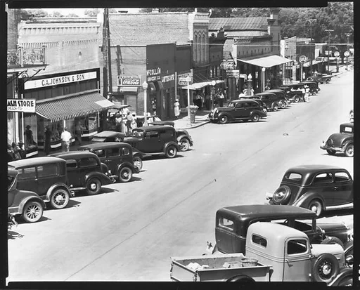 [Parked Cars and Pedestrians on Main Street, From Elevated Position, Greensboro, Alabama]