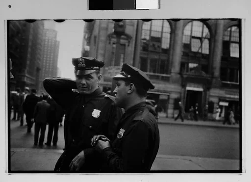 [Two 35mm Film Frames: Two Policemen in Conversation on Street and Barber Shop and NRA Signs in Window, New York City]