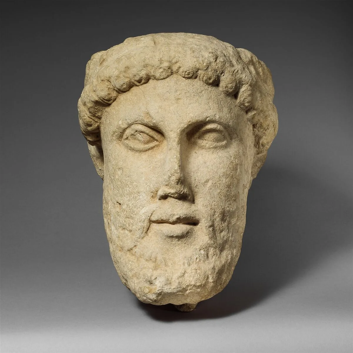 Limestone head of a bearded male with a wreath of leaves — Unknown
