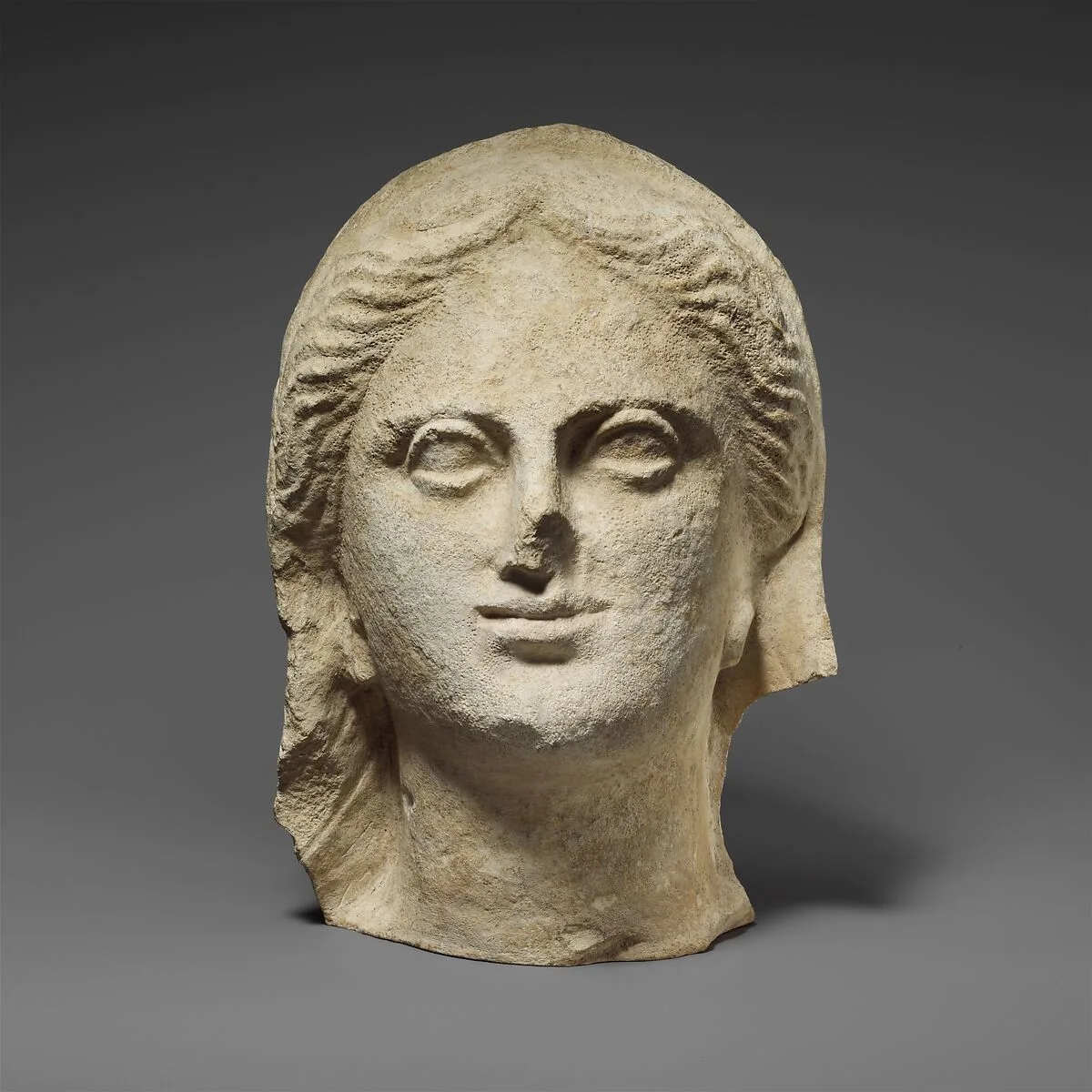 Limestone head of a veiled female votary — Unknown