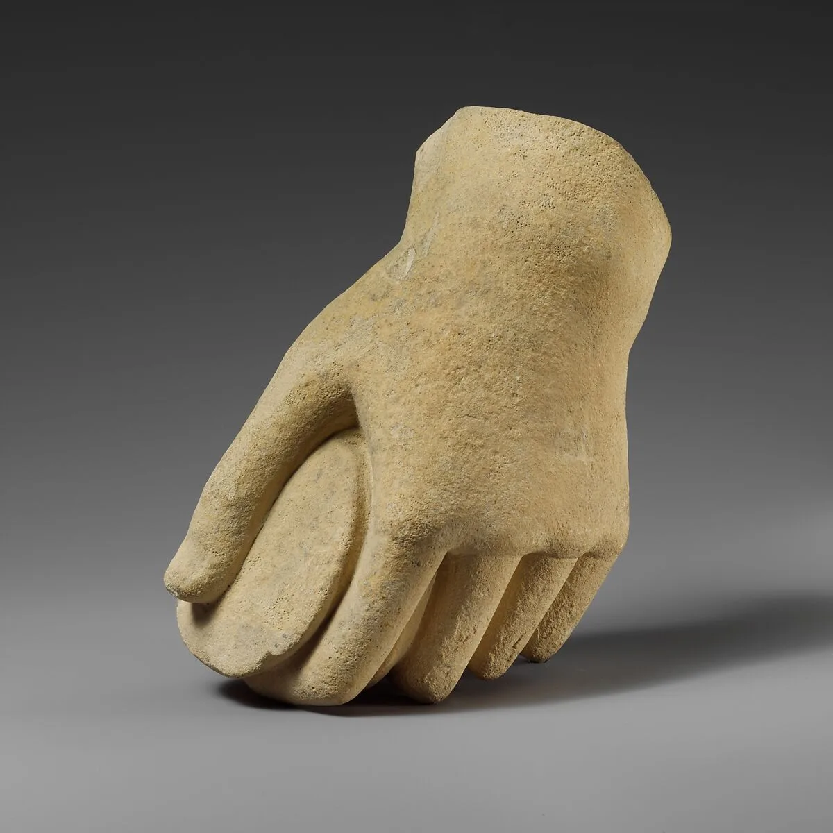 Limestone hand holding a pyxis — Unknown