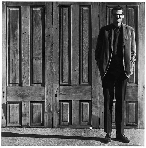 [Man Standing in Front of Three Wooden Doors]