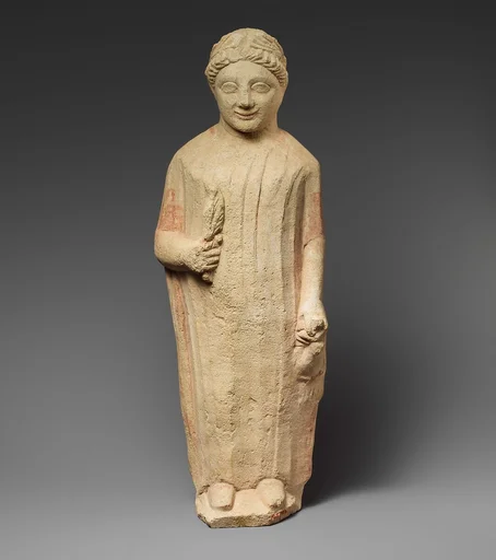 Limestone statuette of a boy holding a bird and a branch of leaves