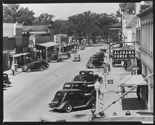 [View of Main Street with Parked Cars, Pedestrians, and Alabama Power Company Sign, Greensboro, Alabama]