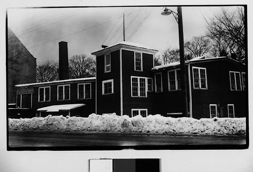 [Wooden Clapboard Building Behind Snow Bank]