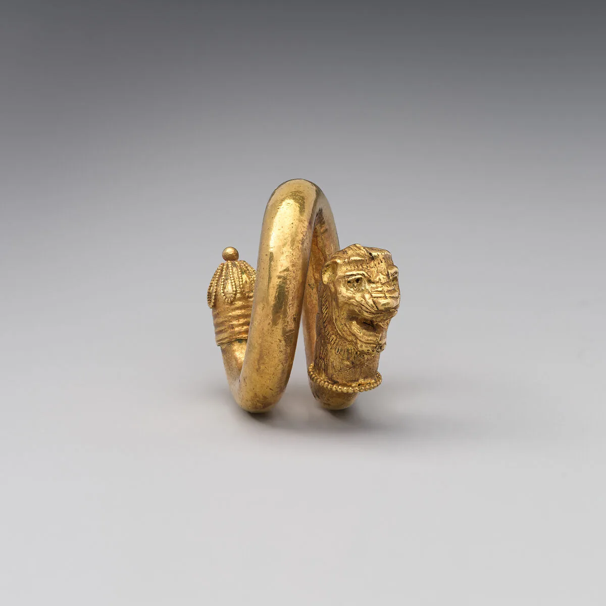 Gold and copper alloy spiral with lion-head terminal — Unknown