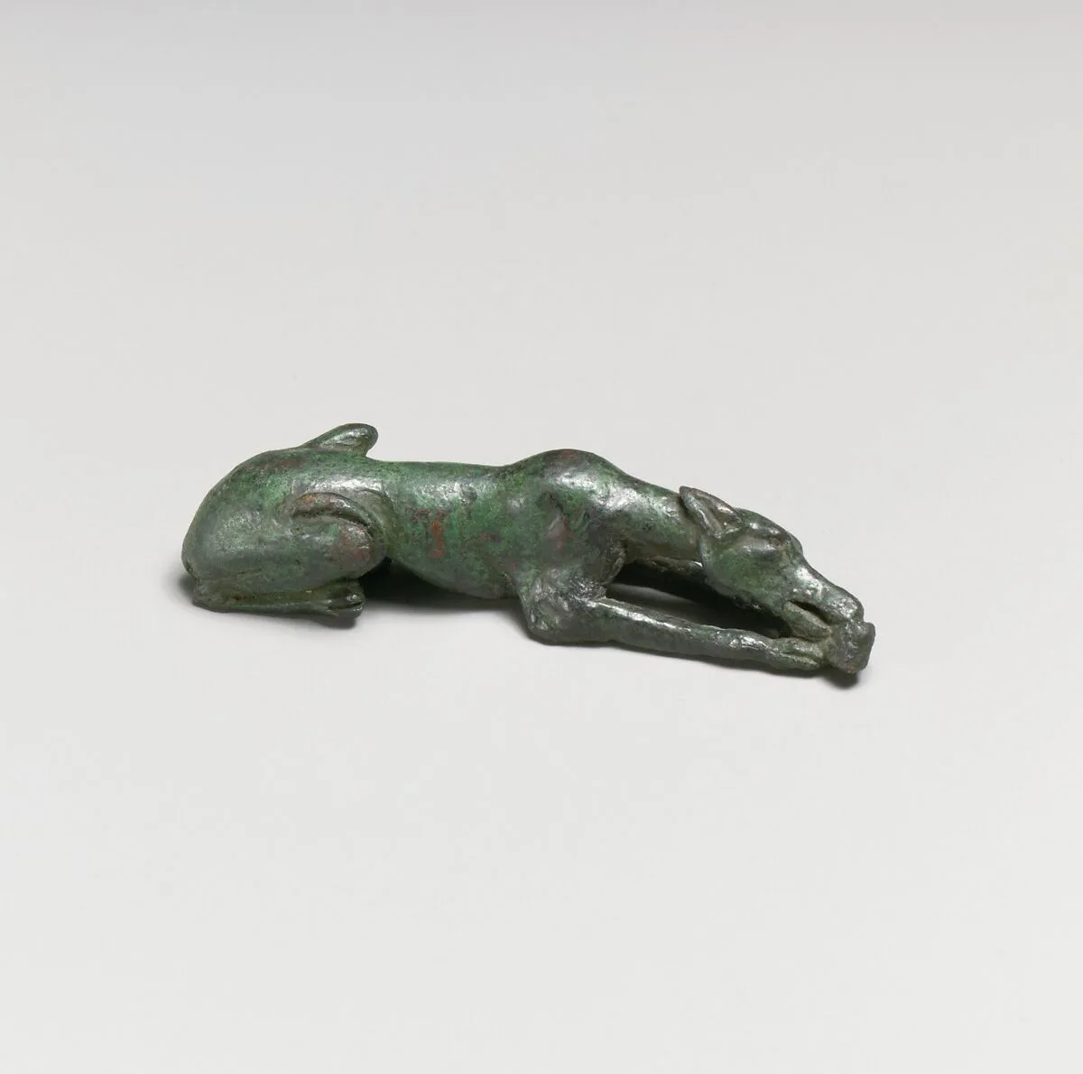 Bronze statuette of a hound gnawing a bone — Unknown