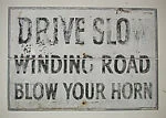 [Stenciled Sign: "Drive Slow, Winding Road, Blow Your Horn"]