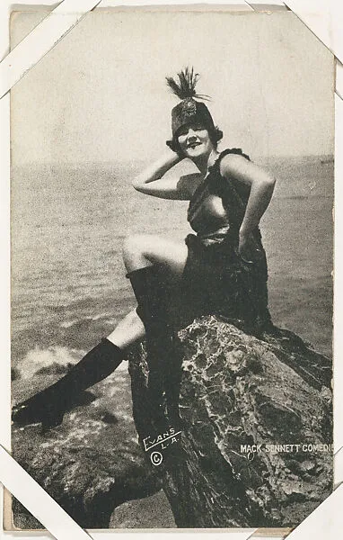Bathing beauty in costume with boots, seated on rock from Mack Sennett Comedies Arcade series (W423) — Unknown
