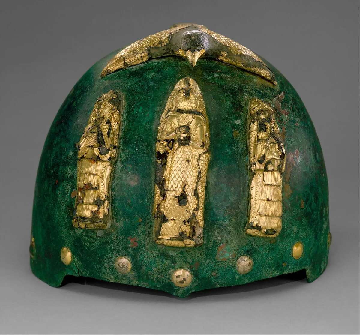 Helmet with divine figures beneath a bird with outstretched wings — Unknown