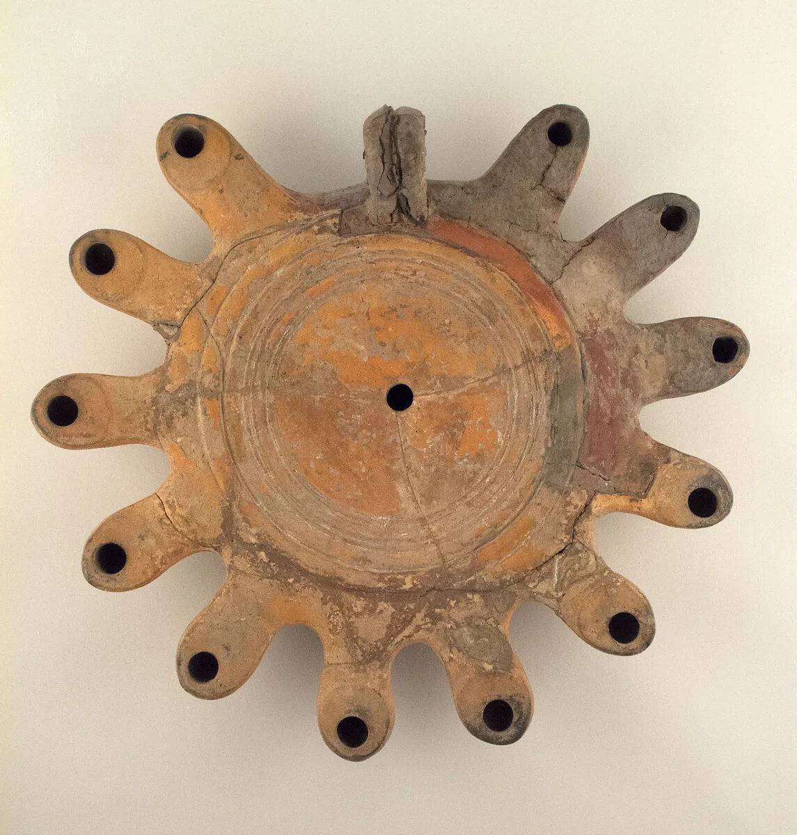 Terracotta lamp with multiple nozzles and ring handle — Unknown