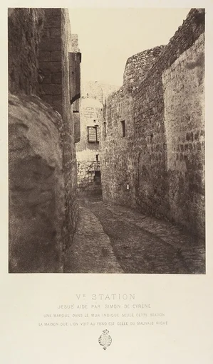 Ve Station. Jésus aidé par Simon de Cyrène. Une marque dans le mur indique seule cette station. La maison que l'on voit au fond est celle du mauvais riche