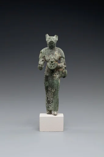 Bastet holding a lion-headed aegis, a sistrum (broken), and a basket