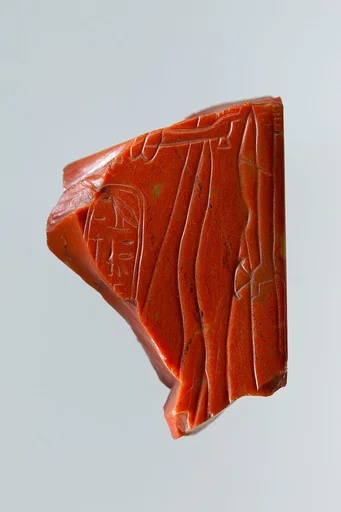 Statue fragment from a standing figure whose back pillar has cartouche of Ramesses II, and the figure of queen Nefertari incised on side