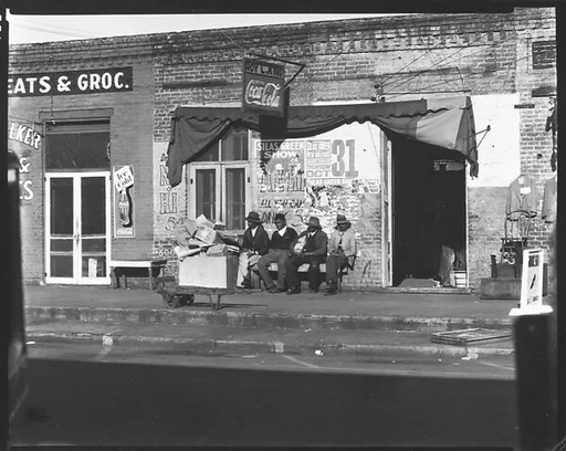 [Men Seated on Bench on Sidewalk, Selma, Alabama]