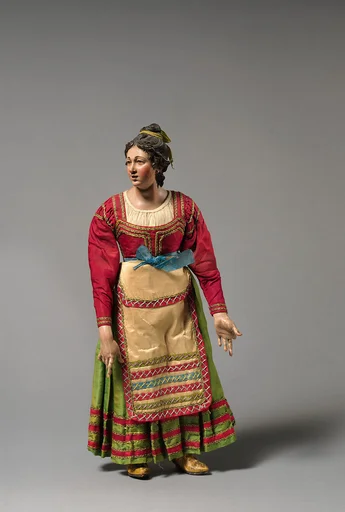 Young woman looking up in red top, green skirt, cream apron