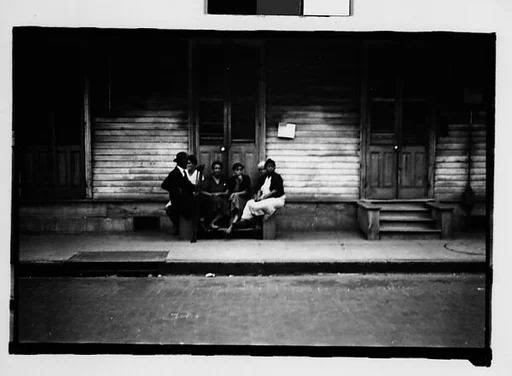 [Group Seated on Stoop in French Quarter, New Orleans, Louisiana]