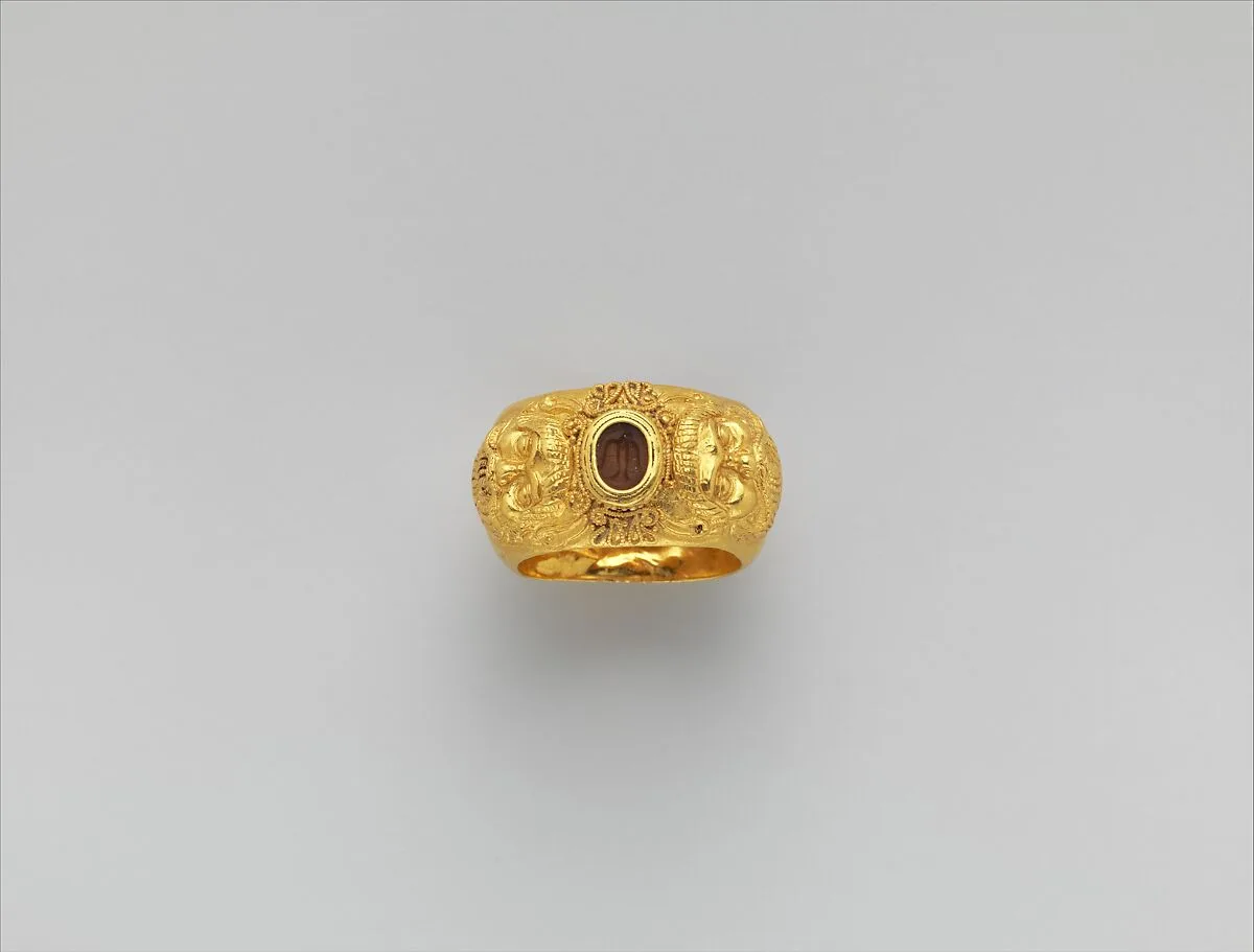 Gold ring with embossed satyr masks: on carnelian intaglio, bird — Unknown