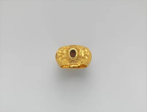 Gold ring with embossed satyr masks: on carnelian intaglio, bird