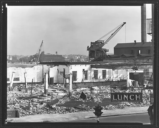[Demolition Site with Cranes and "Lunch" Sign in Foreground, New York City]