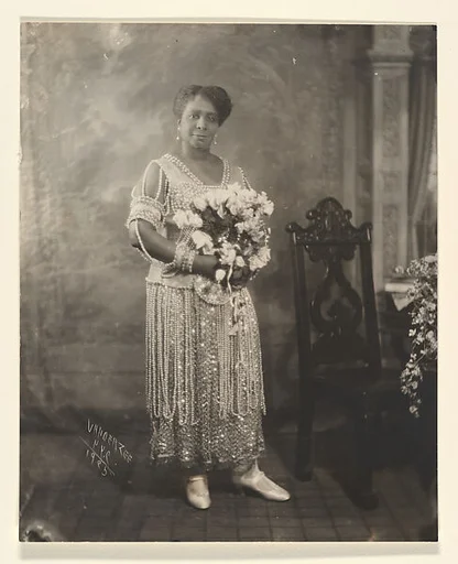 [Woman in Dress with Sequins and Pearls in Front of Painted Backdrop]