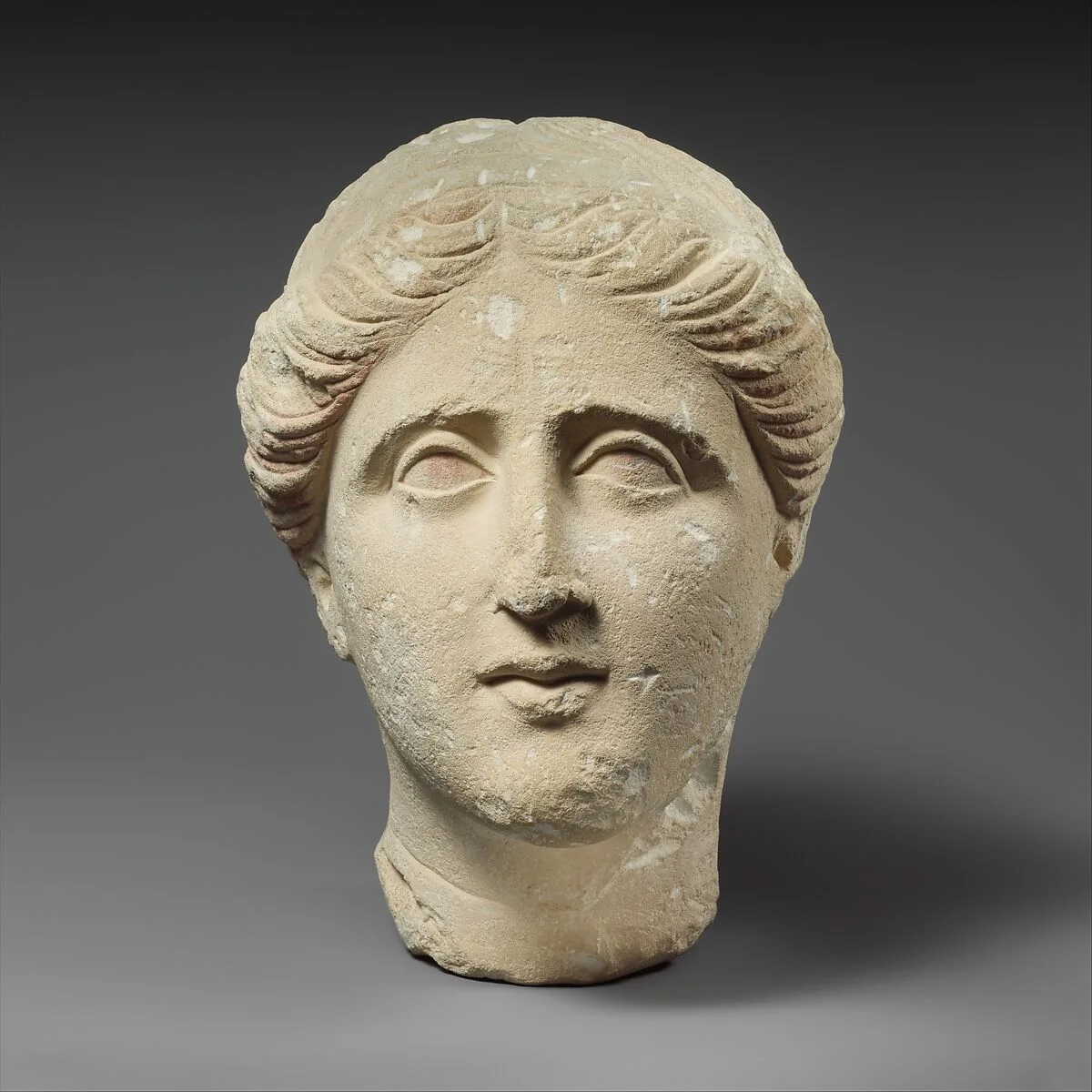 Limestone head of a female votary — Unknown
