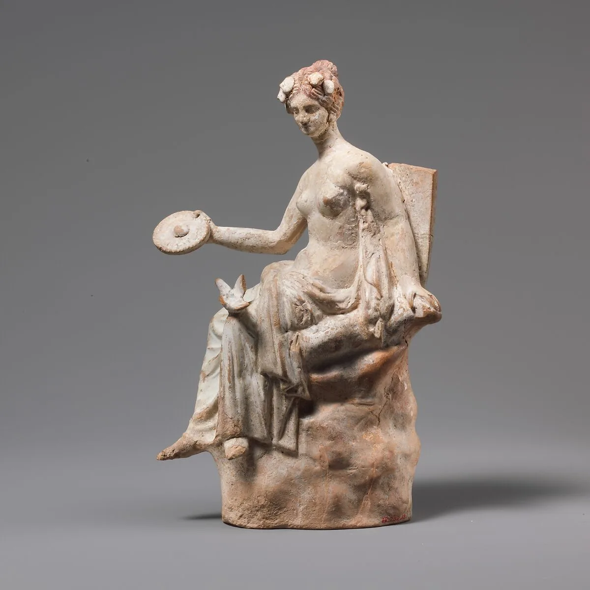 Terracotta statuette of Aphrodite seated on a rock — Unknown