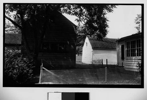 [Clapboard House and Barns Behind Wire Fence]