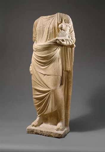 Limestone statue of a man holding a mask in the form of a bull's head