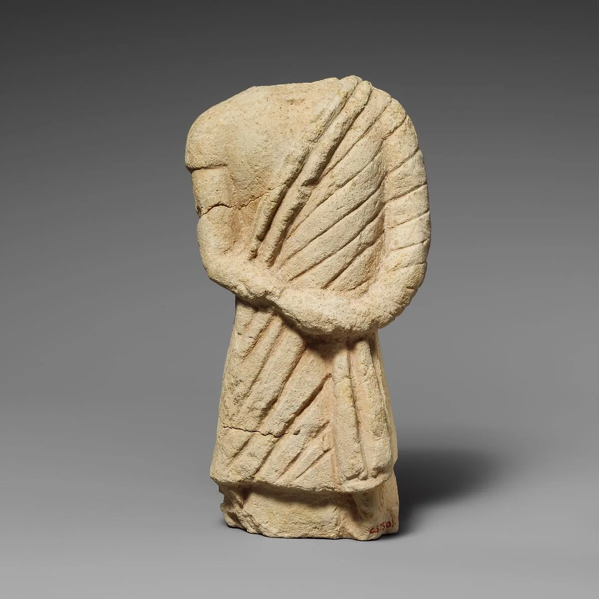 Fragment of a limestone statuette of a male votary — Unknown