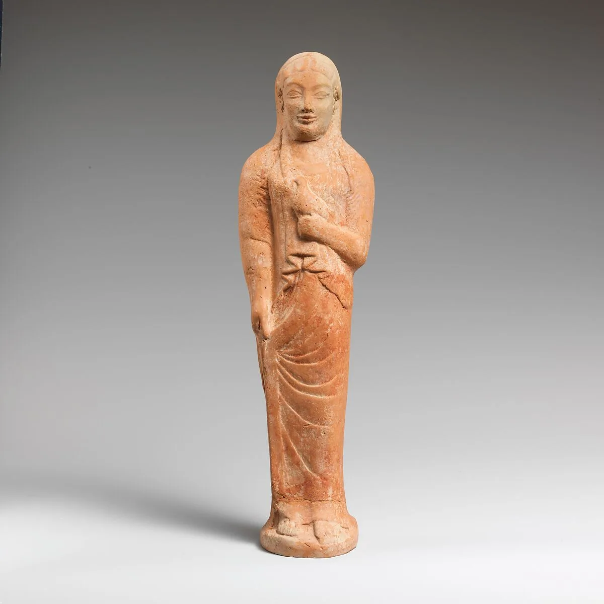 Terracotta statuette of a woman holding a bird — Unknown
