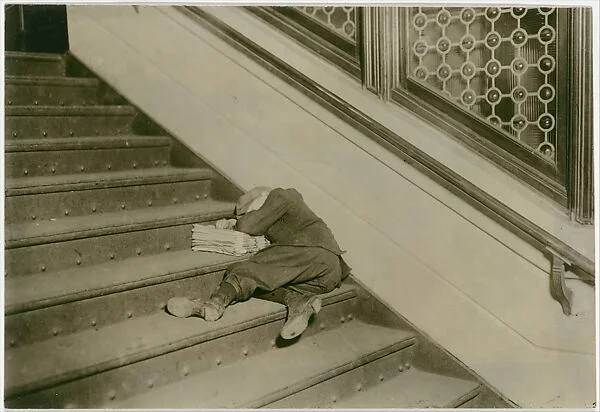 Newsboy asleep on stairs with papers, Jersey City, New Jersey — Lewis Hine