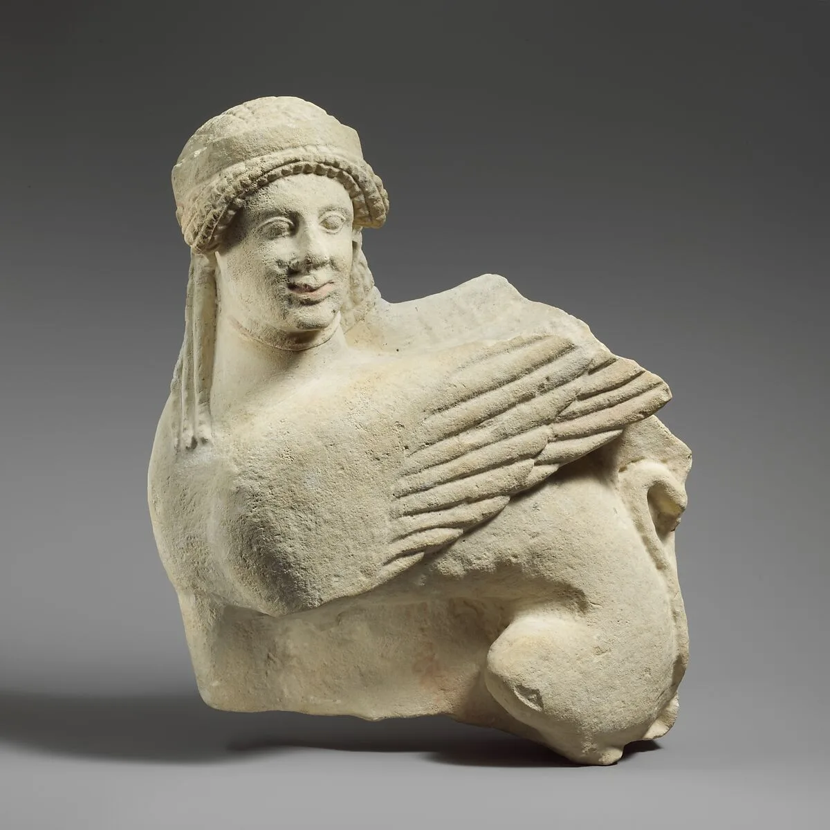 Fragment of a limestone funerary stele with a seated sphinx — Unknown