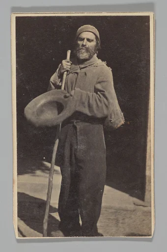 [Studio Portrait: Man with Walking Stick Begging (?)]