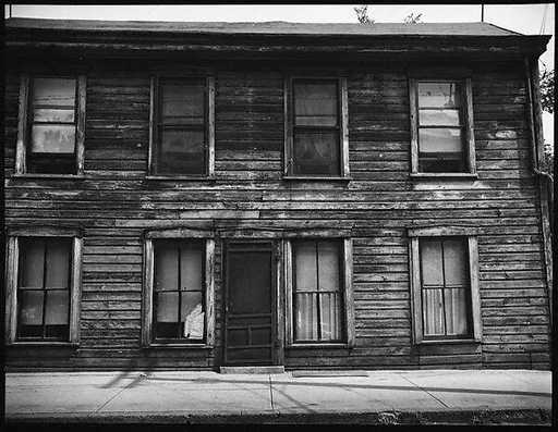 [Clapboard House with Telephone Pole Shadows Along Sidewalk]