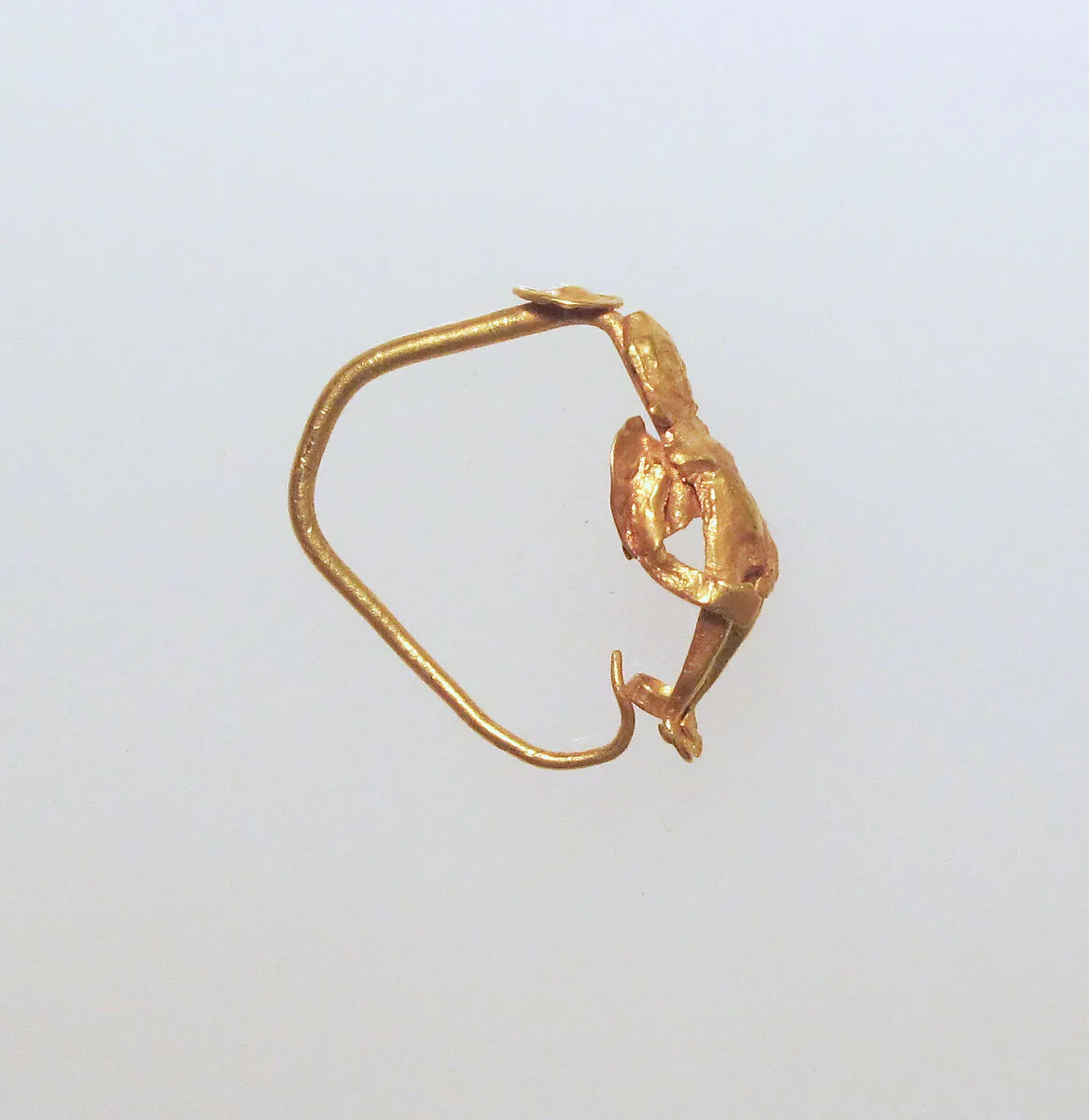 Gold earring with winged figure — Unknown