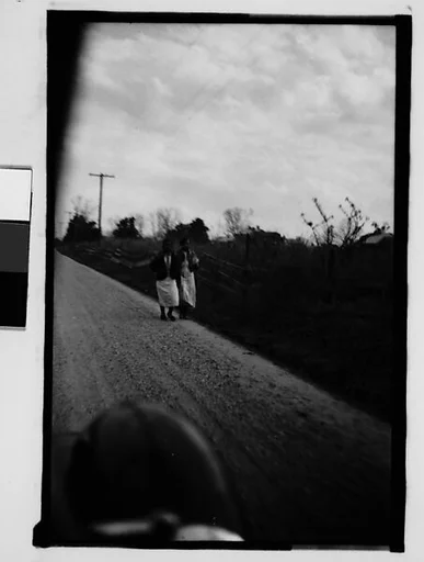 [Two Women Walking by Side of Road, From Moving Automobile, New Orleans Vicinity, Louisiana]