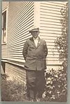 [Ira Denman Standing Before Corner of House]