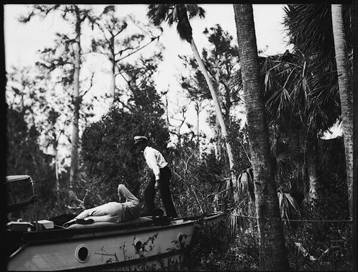[Two Unidentified Men on Prow of Moored Dayboat in Everglades, Florida]