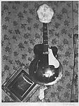 [Guitar and Hat Against Floral Wallpaper]