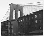 [View of Brooklyn Bridge Behind Tenement Houses]