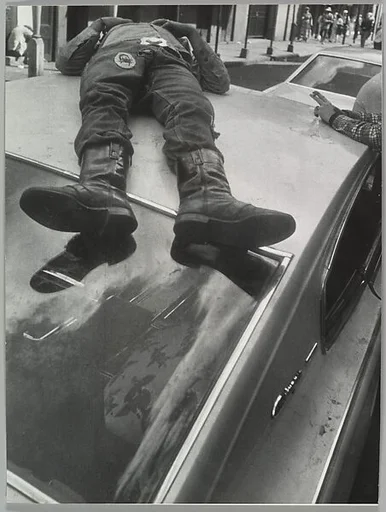 [Man Lying on Roof of Car]