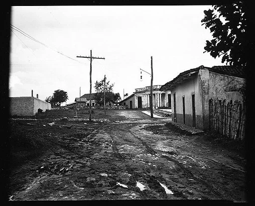 [Houses and Power Lines on Dirt Road, Cuba]