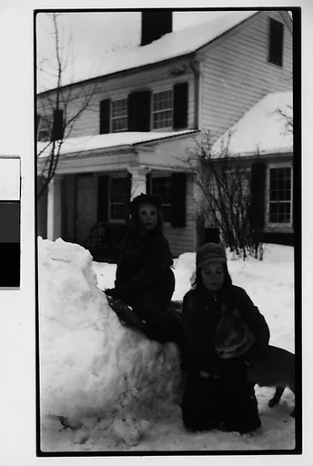 [Two Children, Possibly Mabry Girls, and Dog on Snowbank in Front of House]
