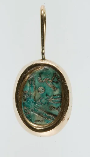 A modern pendant setting holding an inscribed scarab