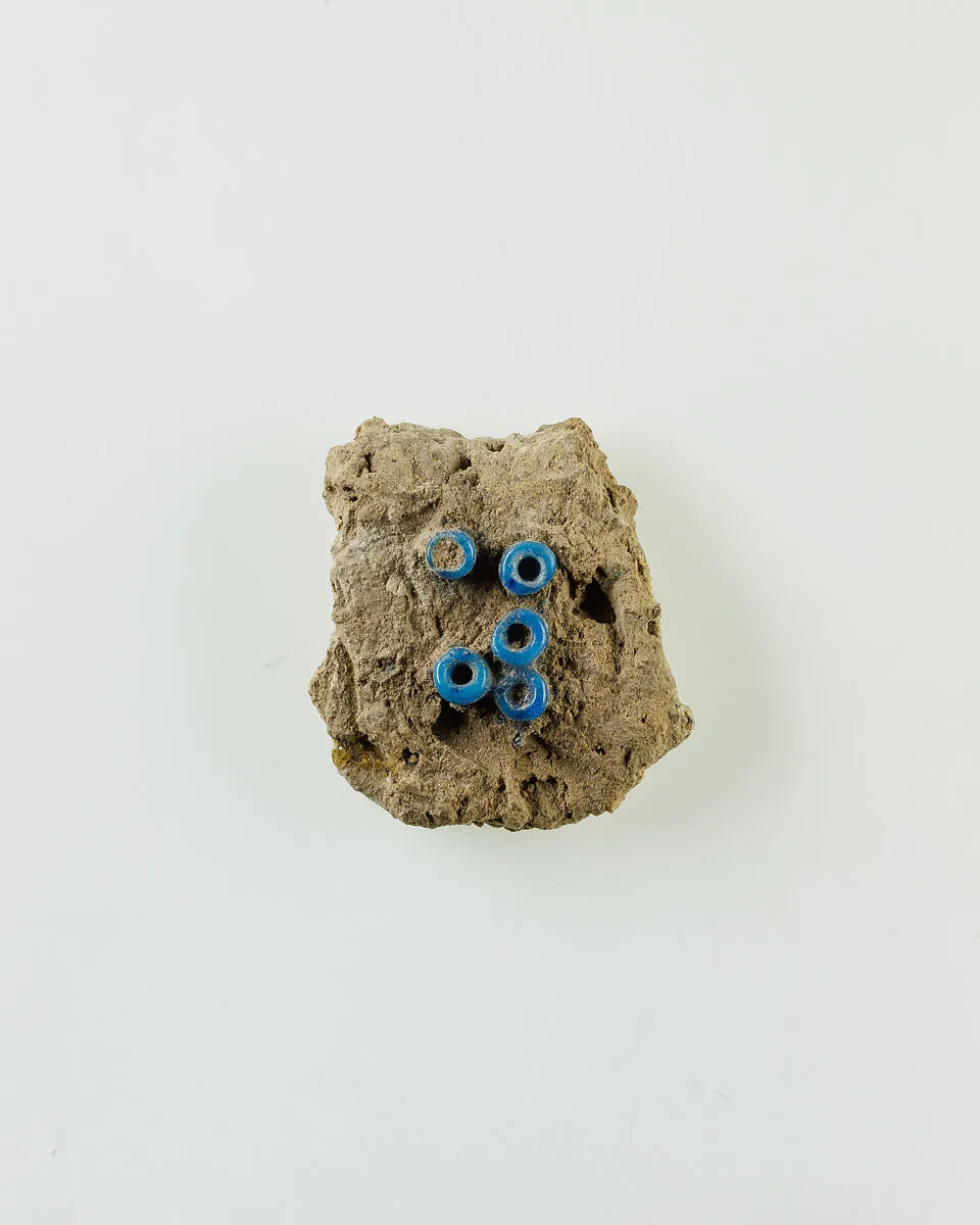 Fragment of clay lump with imbedded ring beads — Unknown