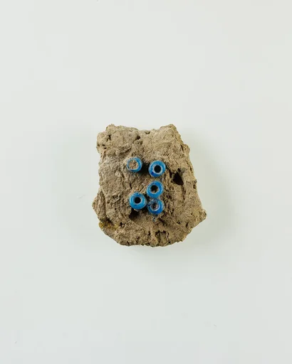 Fragment of clay lump with imbedded ring beads