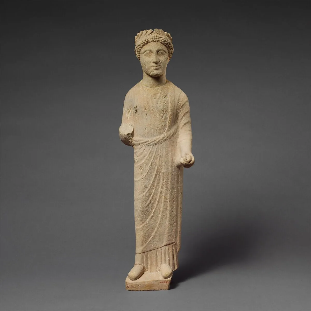 Limestone statuette of a beardless male votary with a wreath of leaves — Unknown