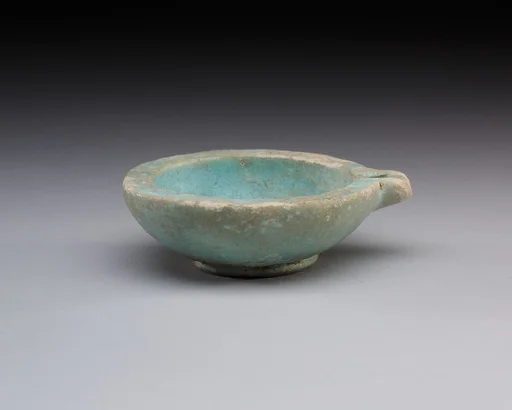 Spouted dish with rosette in the center, traces on the rim where two lions were attached