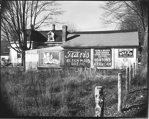 [Advertisements on Barn Façade Behind Folk Victorian House]